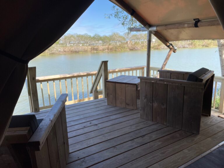View from inside a glamping tent onto a private deck overlooking the Rio Grande