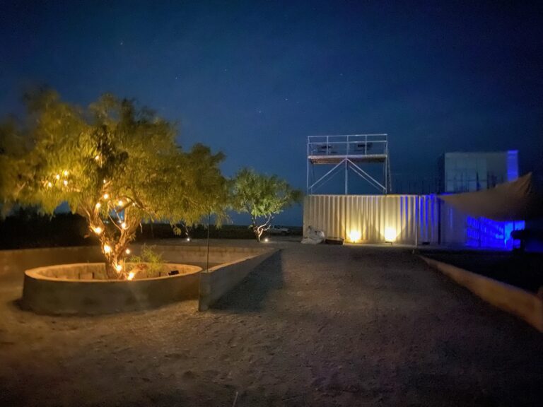 Fire pit and the Rocket Ranch Outpost viewing tower lit up at night near Starbase, Texas
