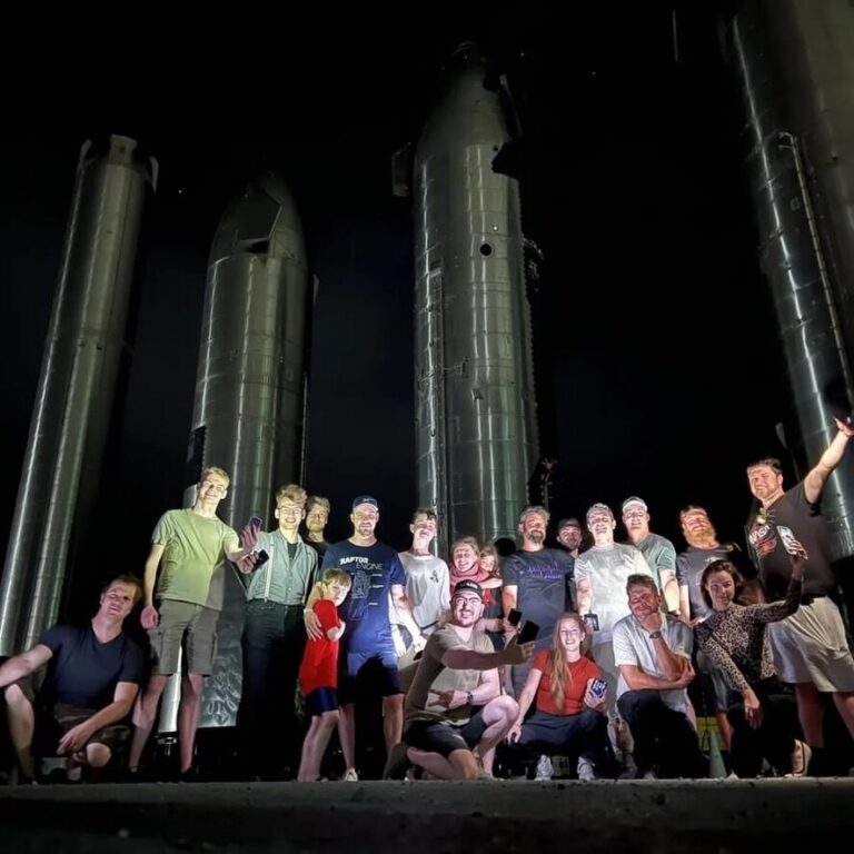 Rocket Ranch guests on an evening outing to the Starbase rocket garden, with Starship rockets lit up behind them