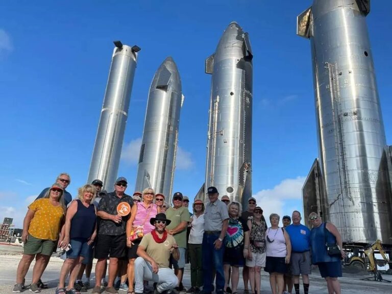 Rocket Ranch guests posing in front of Starship prototypes at the Starbase rocket garden