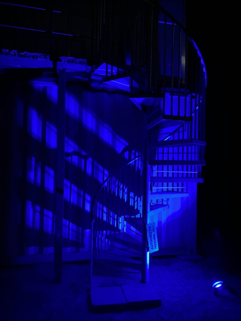 Spiral staircase lit blue at night at Rocket Ranch near Starbase, Texas