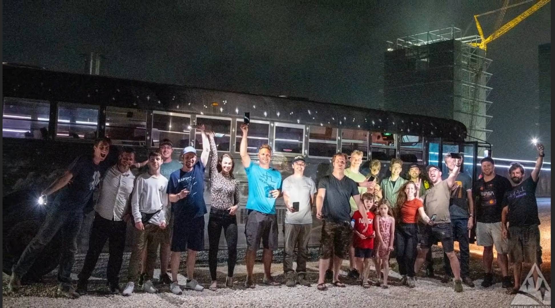 Guests beside the Rocket Ranch shuttle bus at night
